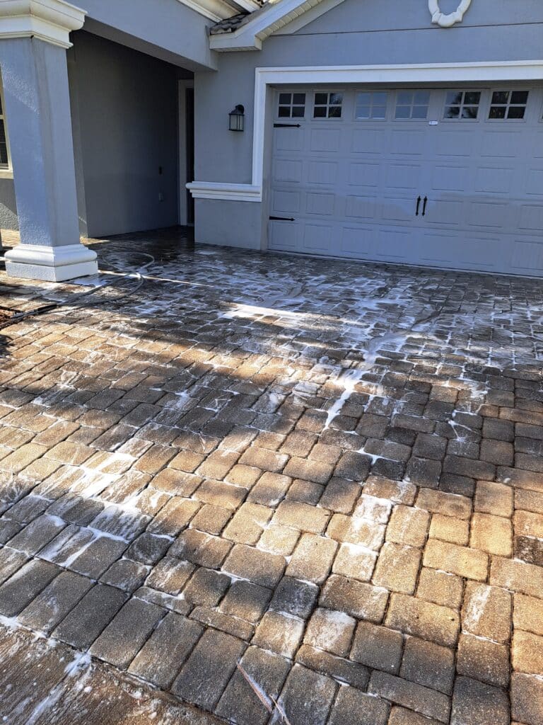 During photo ALT:
Technician performing paver driveway pressure washing
